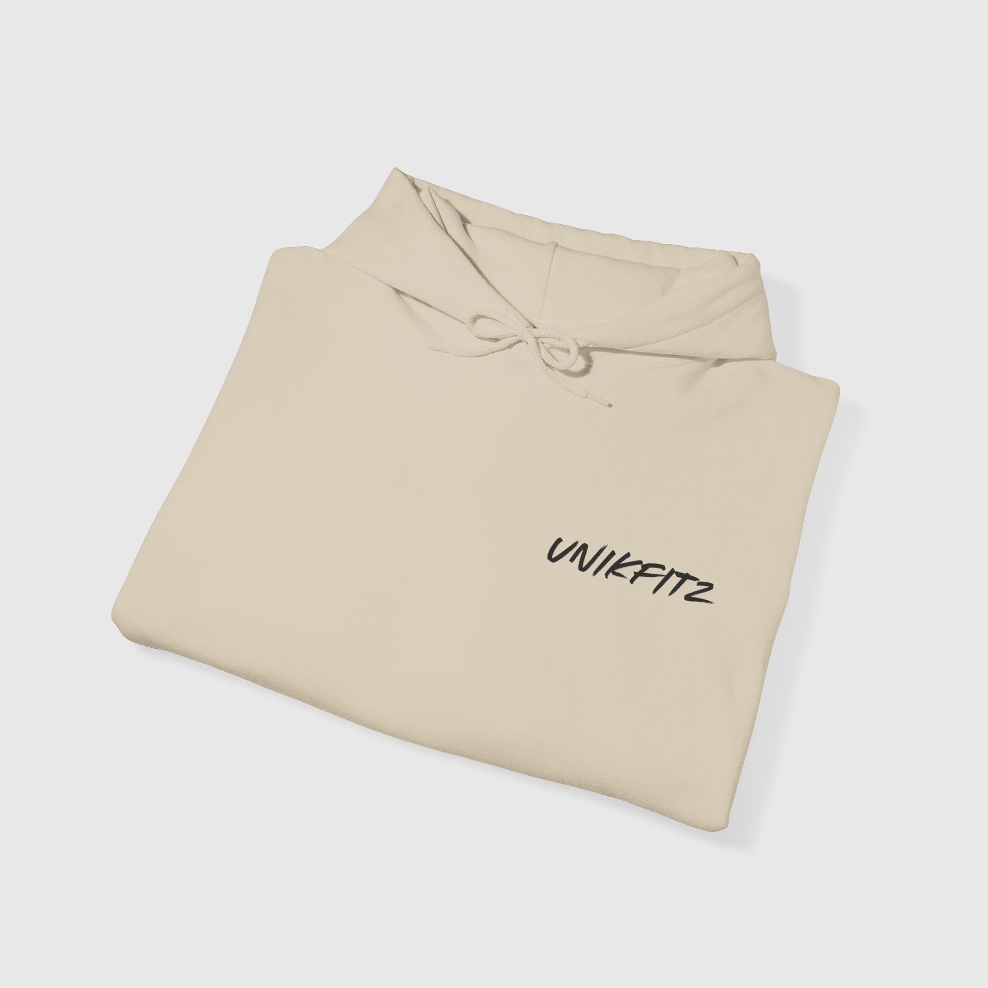 A neatly folded Born to Disrupt hoodie in beige, featuring the UNIKFITZ logo on the front. Perfect men's hoodie for gym wear or streetwear, combining comfort and style