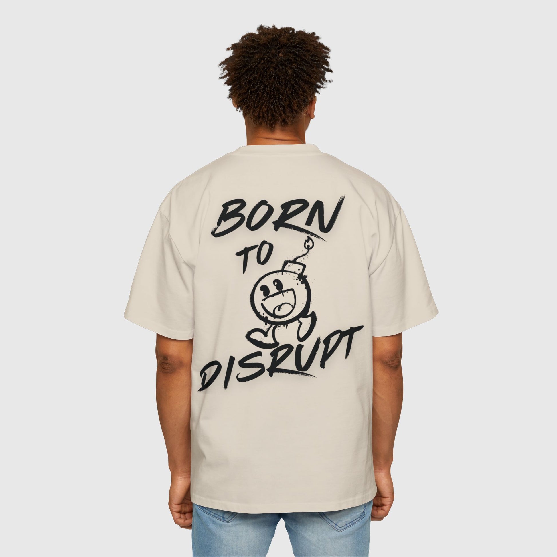 Man wearing a stylish cream oversized T-shirt with bold 'Born to Disrupt' graphic on the back, ideal for street wear and casual men's clothing