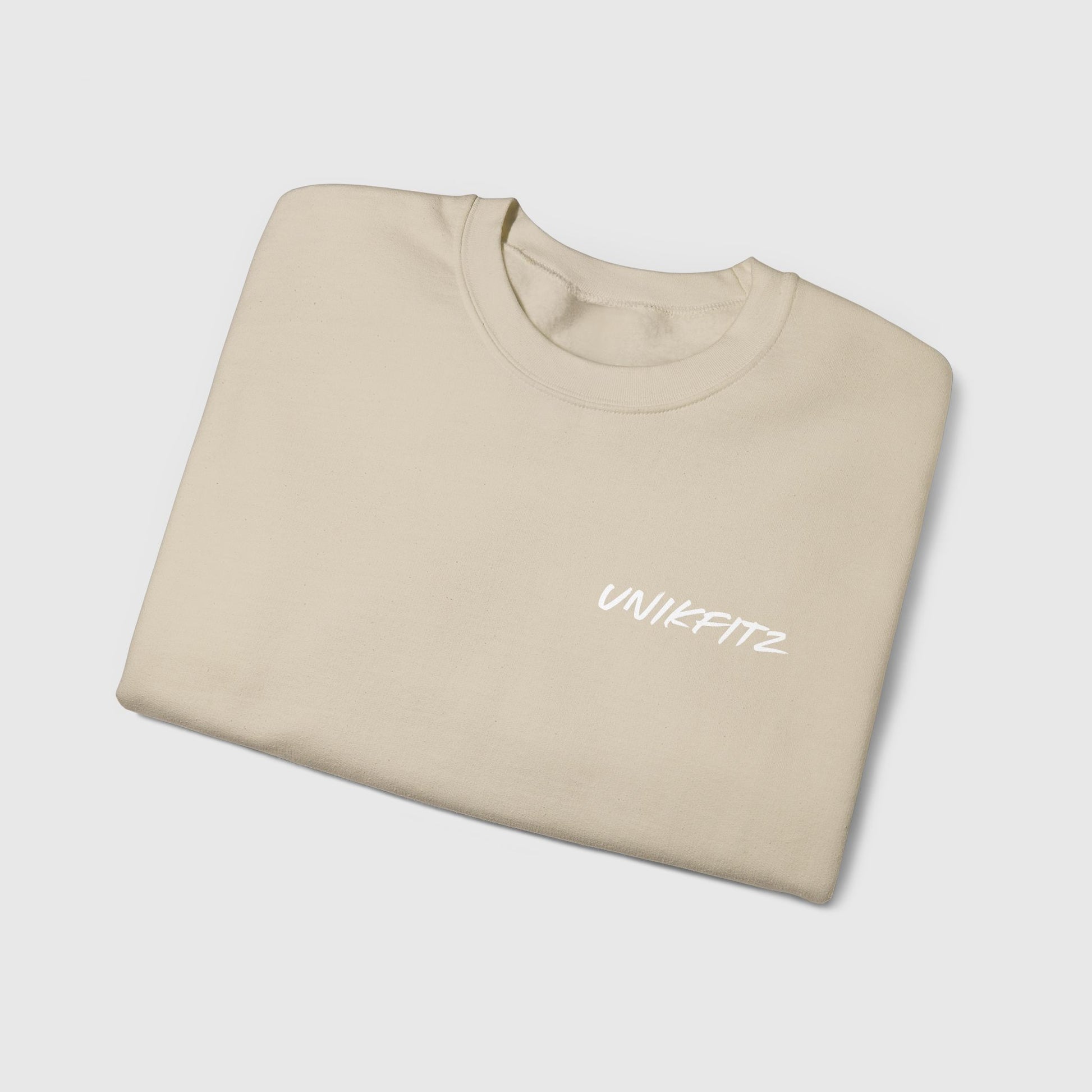 Folded beige sweatshirt showcasing a minimalistic "UNIKFITZ" logo on the chest. Perfect for street wear and gym looks, this essential sweatshirt embodies effortless men's clothing style