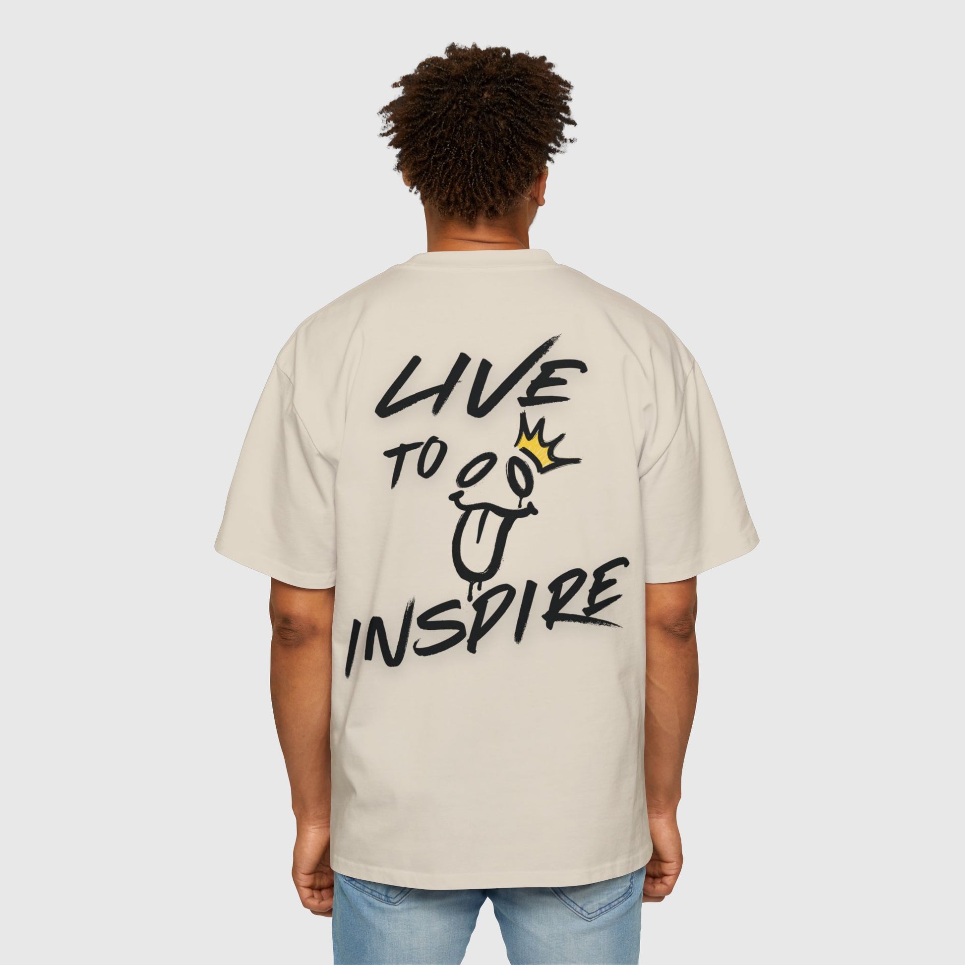 A man showcasing the back of a beige oversized UNIKFITZ T-shirt with a bold "Live to Inspire" graphic, embodying modern streetwear style and self-expression