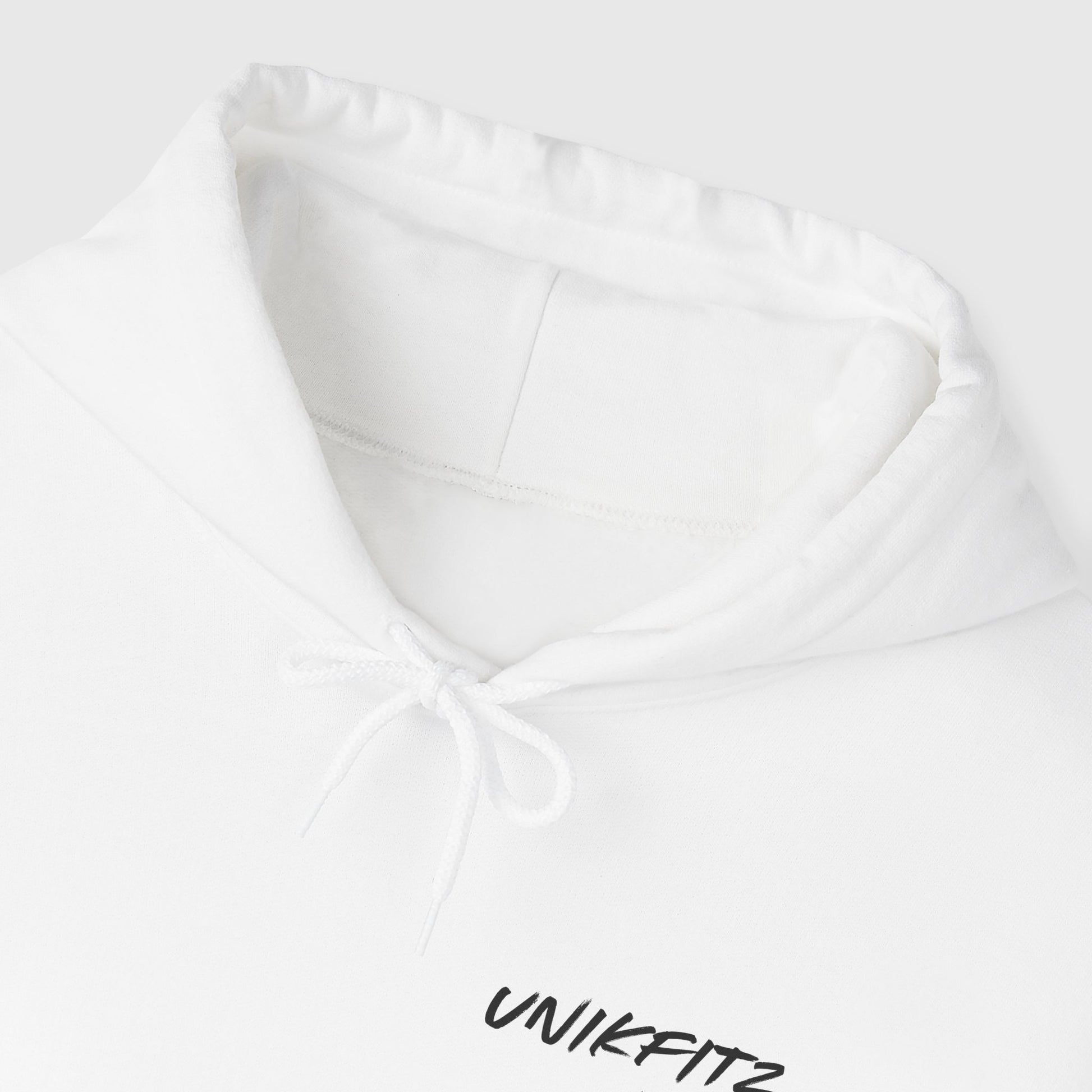 Close-up of the hood and drawstrings on a white men's hoodie by UNIKFITZ, highlighting quality craftsmanship for essential hoodie wear and men's clothing gym style