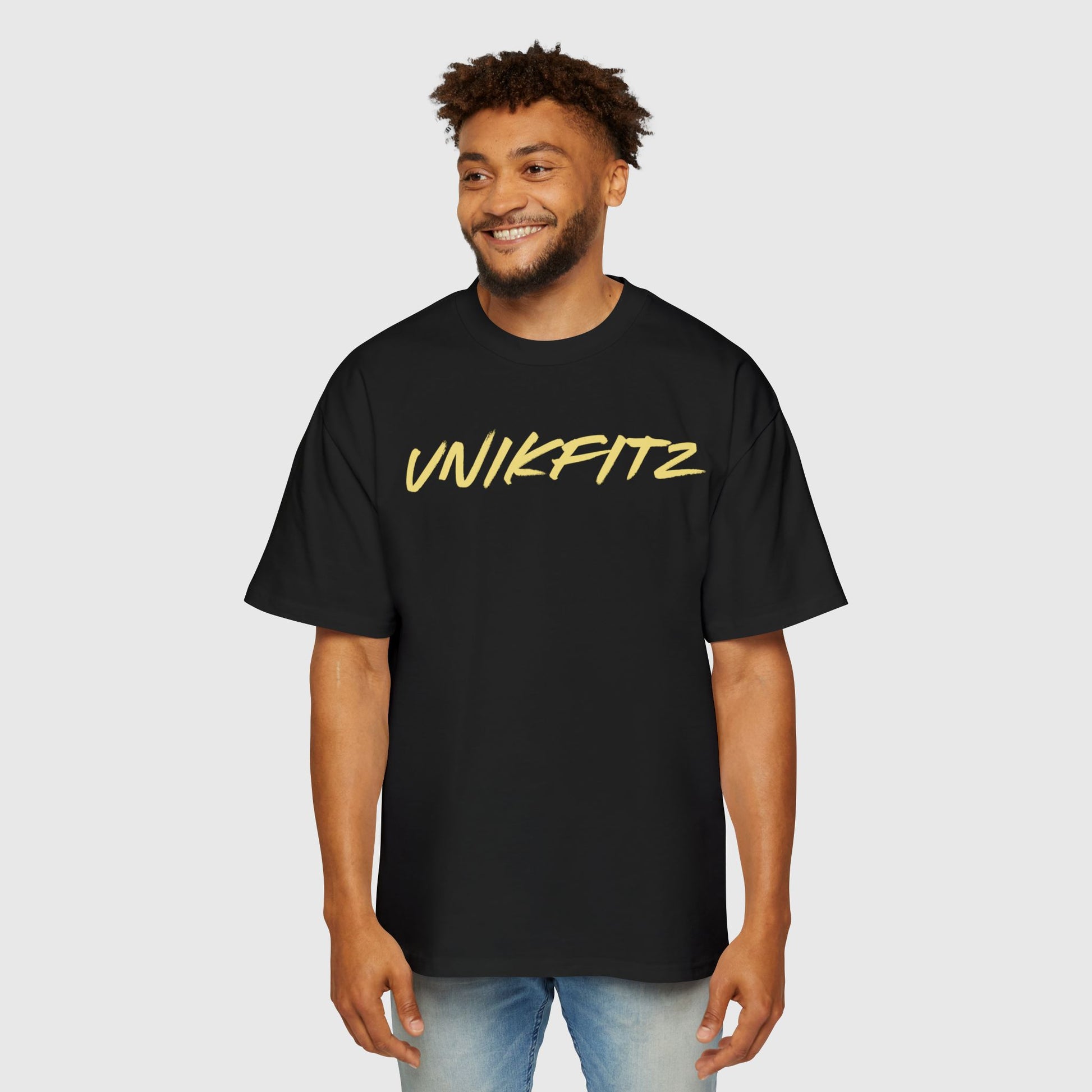 Man wearing a black UNIKFITZ T-shirt with bold yellow lettering, styled as casual men's clothing perfect for street wear and gym fashion. This essential sweatshirt for men combines versatile comfort with a trendy aesthetic, ideal for both casual outings and active wear.