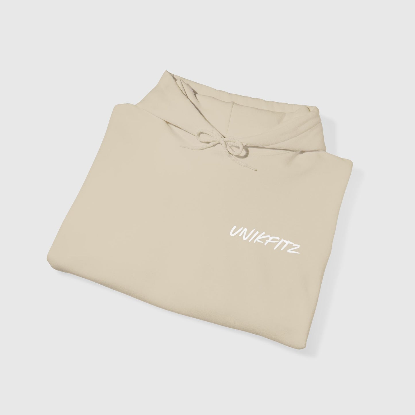 Folded beige hoodie with 'UNIKFITZ' logo visible on the chest, embodying essential men's clothing gym and streetwear vibes, ideal for the modern hoodie for men.