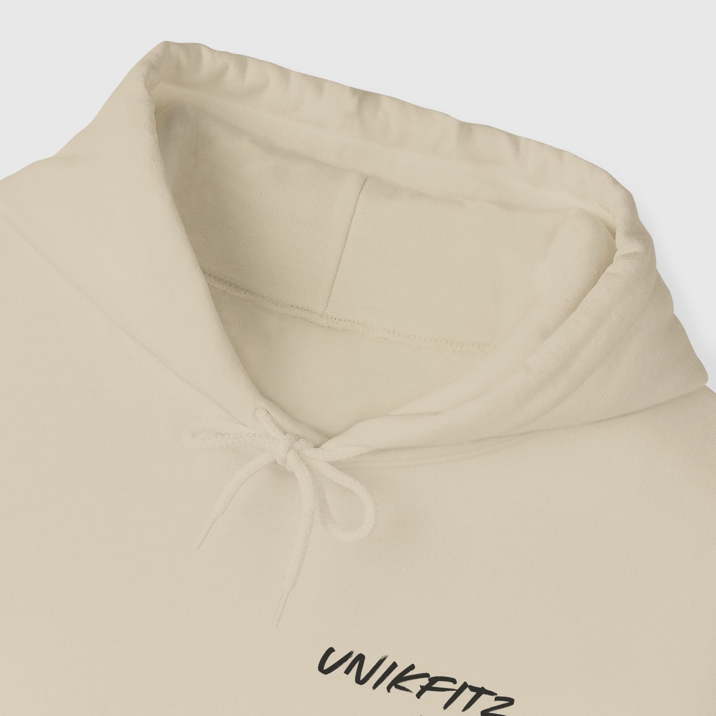 Closeup of a men's hoodie in beige, featuring the Unikfitz logo. Essential streetwear for gym, casual wear, or any fearless misfit's wardrobe. A sleek and timeless men's clothing piece