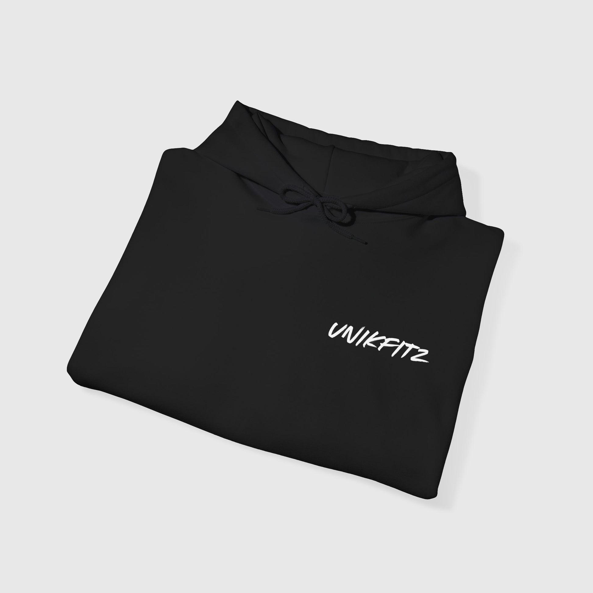 Folded black men's hoodie featuring a minimal UNIKFITZ logo, perfect streetwear for men's clothing gym and casual outfits. Essential hoodie for fearless misfits