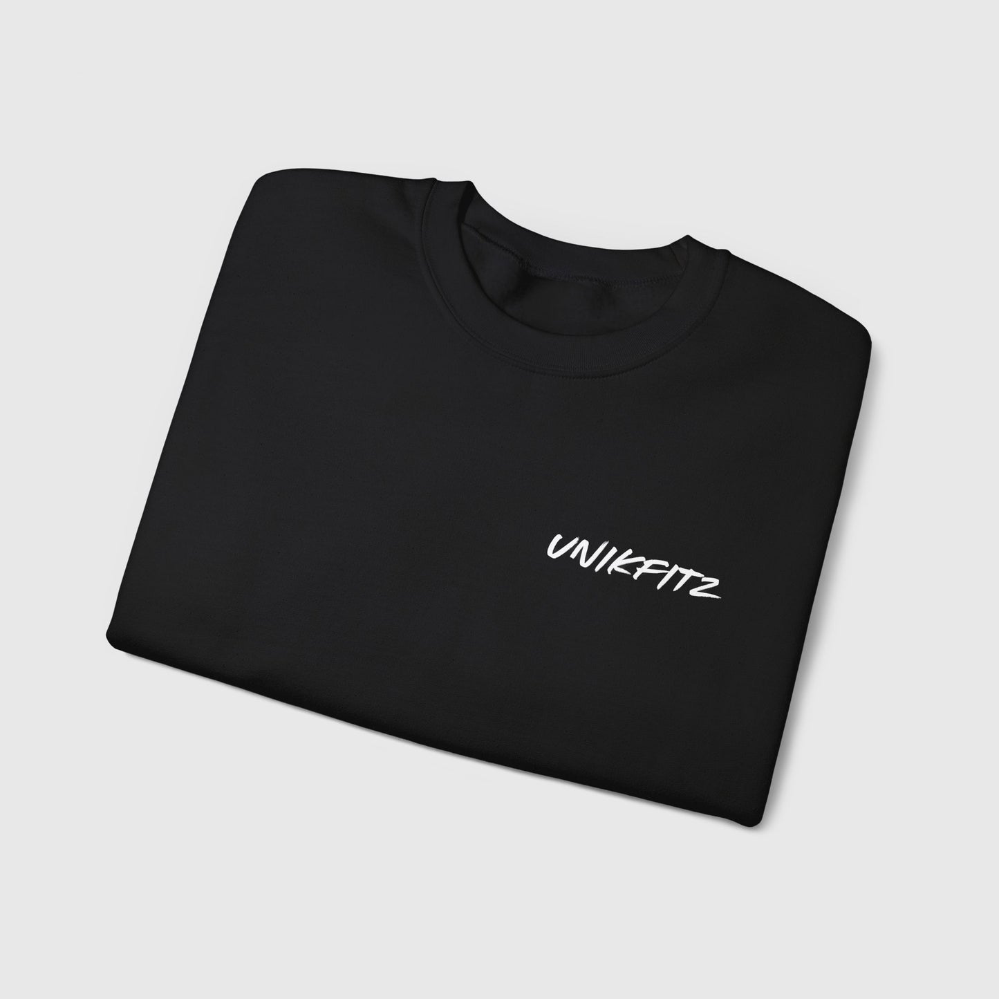 Folded black essential sweatshirt for men with 'Unikfitz' logo on the chest, perfect for men's wear and streetwear enthusiasts. A versatile piece of men's clothing gym style