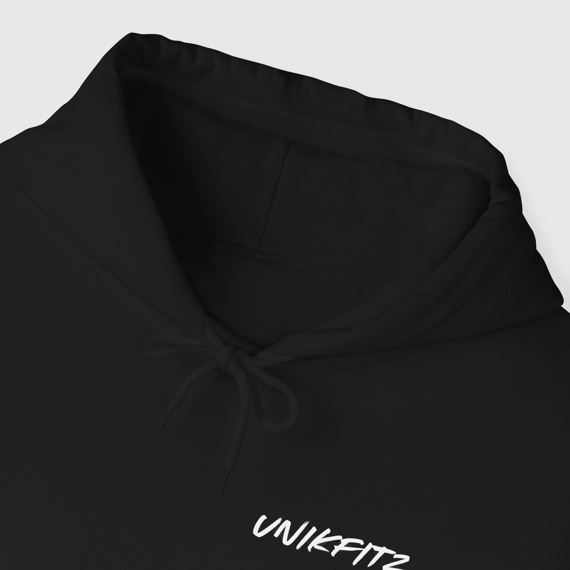 Close-up view of a black essential hoodie for men with minimalist 'UNIKFITZ' text logo. Perfect for street wear, men's clothing gym styles, and casual men's wear outfits