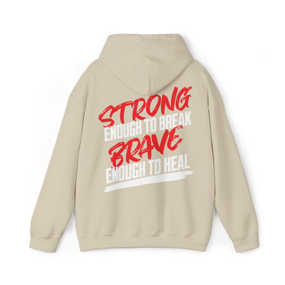 Back view of a beige women's hoodie showcasing a bold red and white motivational print reading 'Strong enough to break, brave enough to heal.' A standout piece for women's clothing and streetwear.