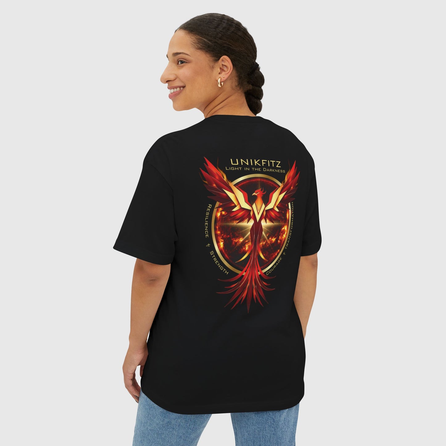 Woman showcasing the back of a black UNIKFITZ T-shirt featuring a vibrant red and gold phoenix design symbolizing resilience and strength. This men's wear street style combines gym-inspired themes with bold artistic details.