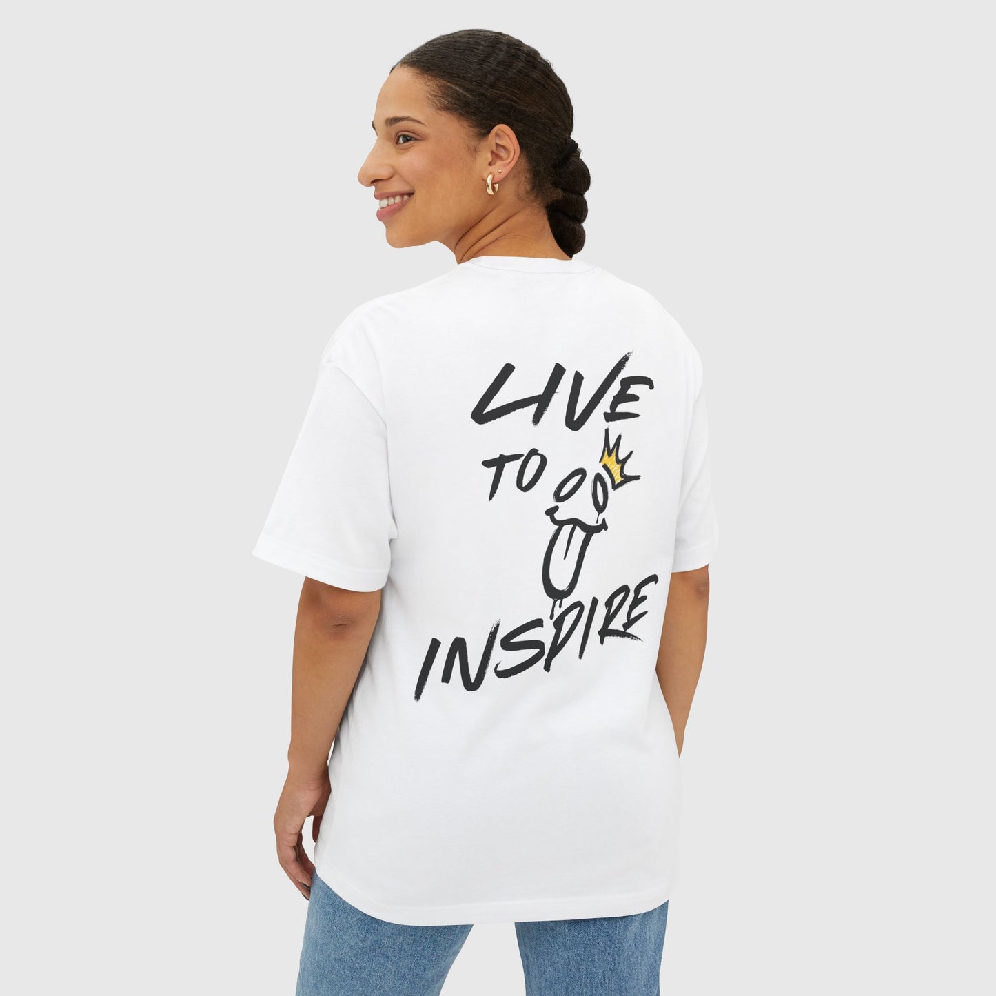 A smiling woman modeling a white oversized "Live to Inspire" graphic T-shirt by UNIKFITZ, featuring a playful design on the back. A perfect blend of comfort and trendy streetwear.