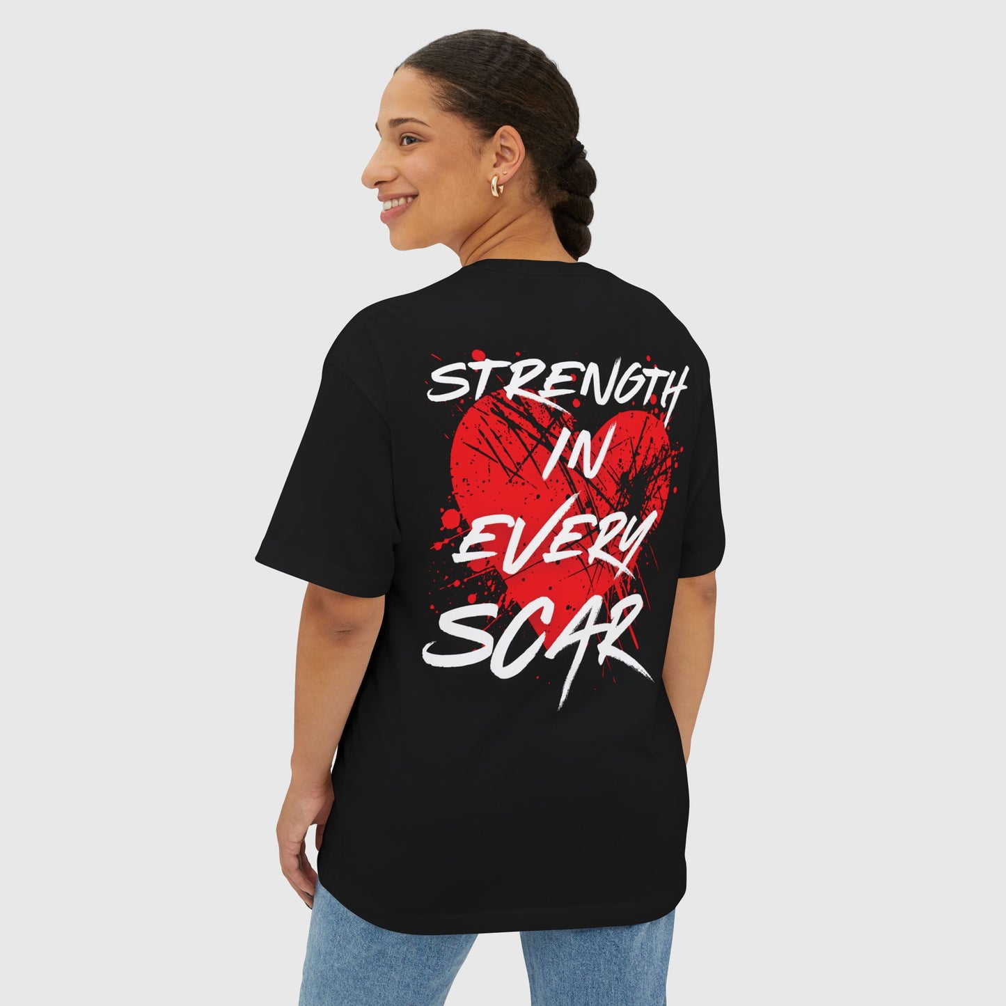 Back view of a woman wearing a black women’s t-shirt with a striking red graffiti heart design and the words "Strength in Every Scar" – women’s t-shirt, street wear, t-shirt essential