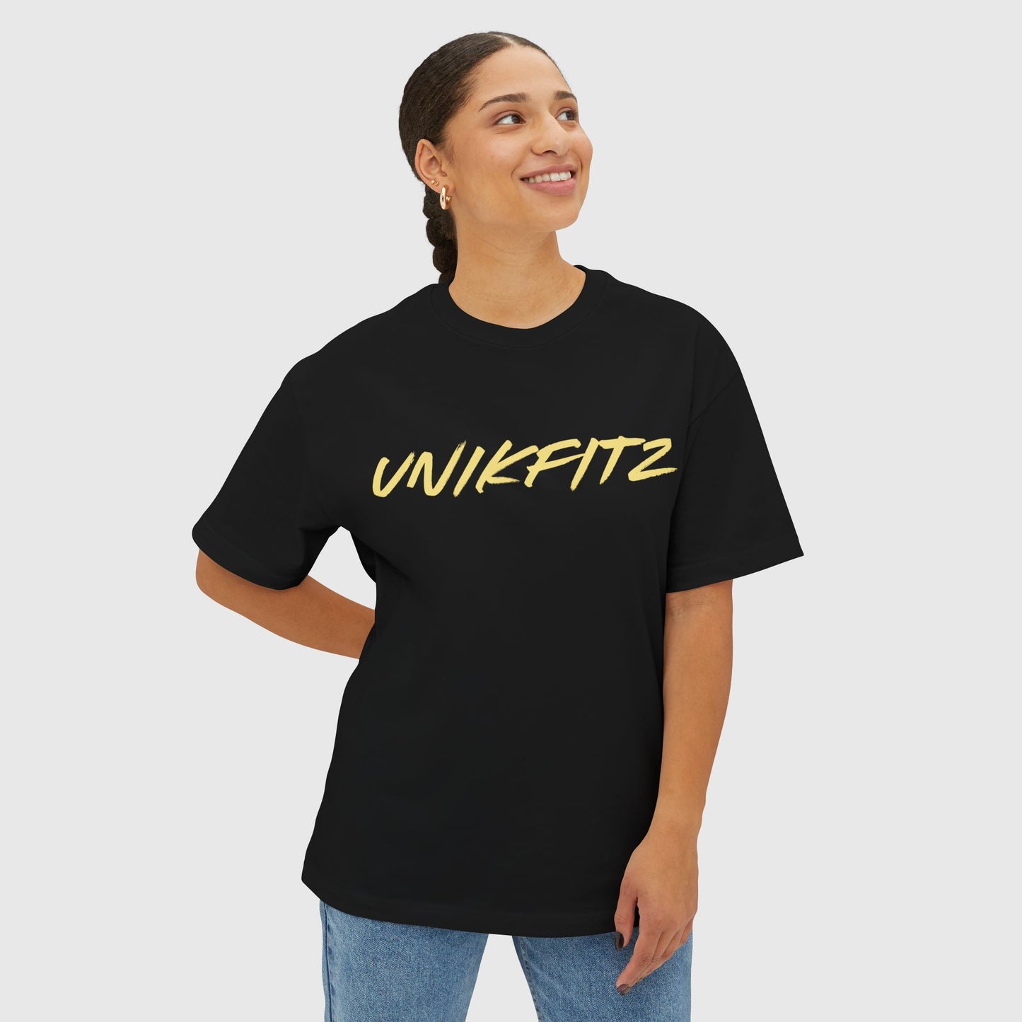 Woman wearing a black UNIKFITZ T-shirt with bold yellow lettering, styled as casual men's clothing that blends street wear and gym fashion. Perfect essential sweatshirt for men's wear enthusiasts looking for versatile and stylish attire.