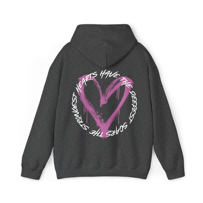 Back view of the Scarred Heart Women's charcoal grey Hoodie with an eye-catching pink heart graphic and motivational quote. This Australian streetwear piece embodies strength and resilience, making it an essential t-shirt alternative for urban fashion lovers.