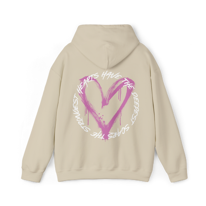 Back view of the Scarred Heart Women's beige Hoodie with an eye-catching pink heart graphic and motivational quote. This Australian streetwear piece embodies strength and resilience, making it an essential t-shirt alternative for urban fashion lovers.