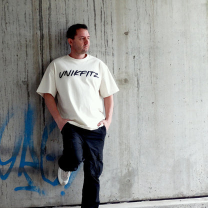 Model wearing the 'Live to Inspire' oversized men's t-shirt by UNIKFITZ in an urban streetwear setting. This premium Australian streetwear men's clothing piece features a relaxed fit, making it the perfect essential t-shirt for men who love street wear and gym-ready fashion.